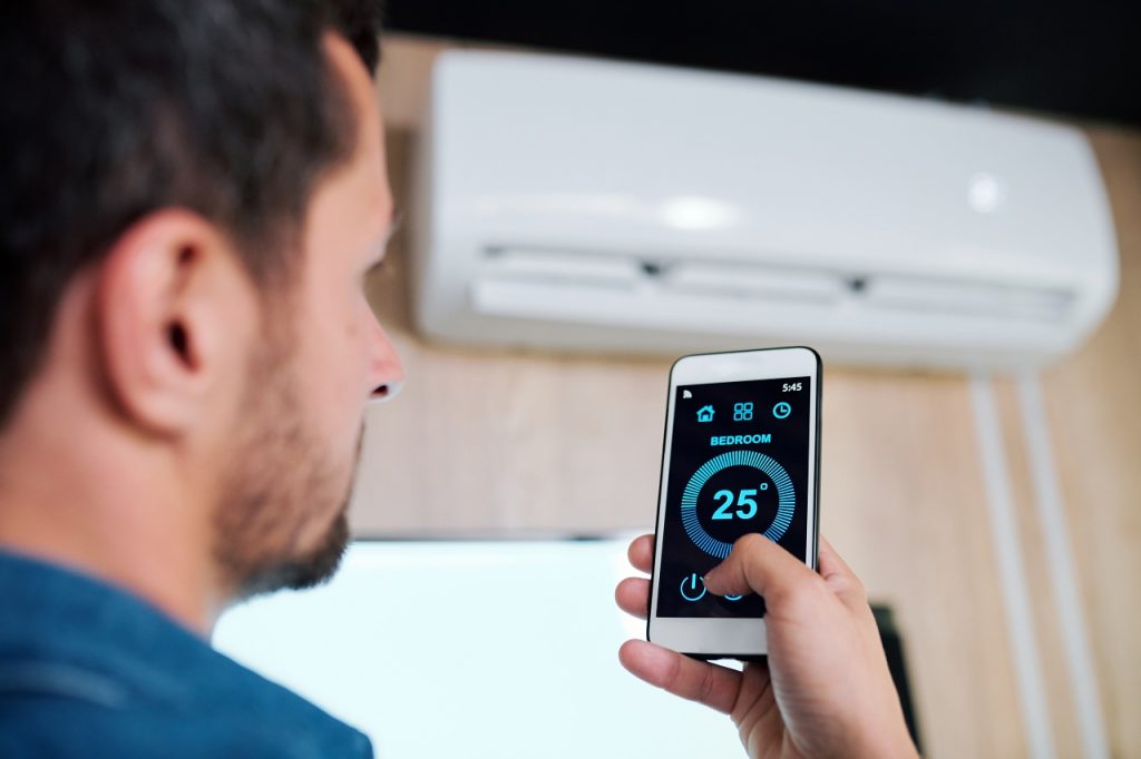 person adjusting room temperature using smart app